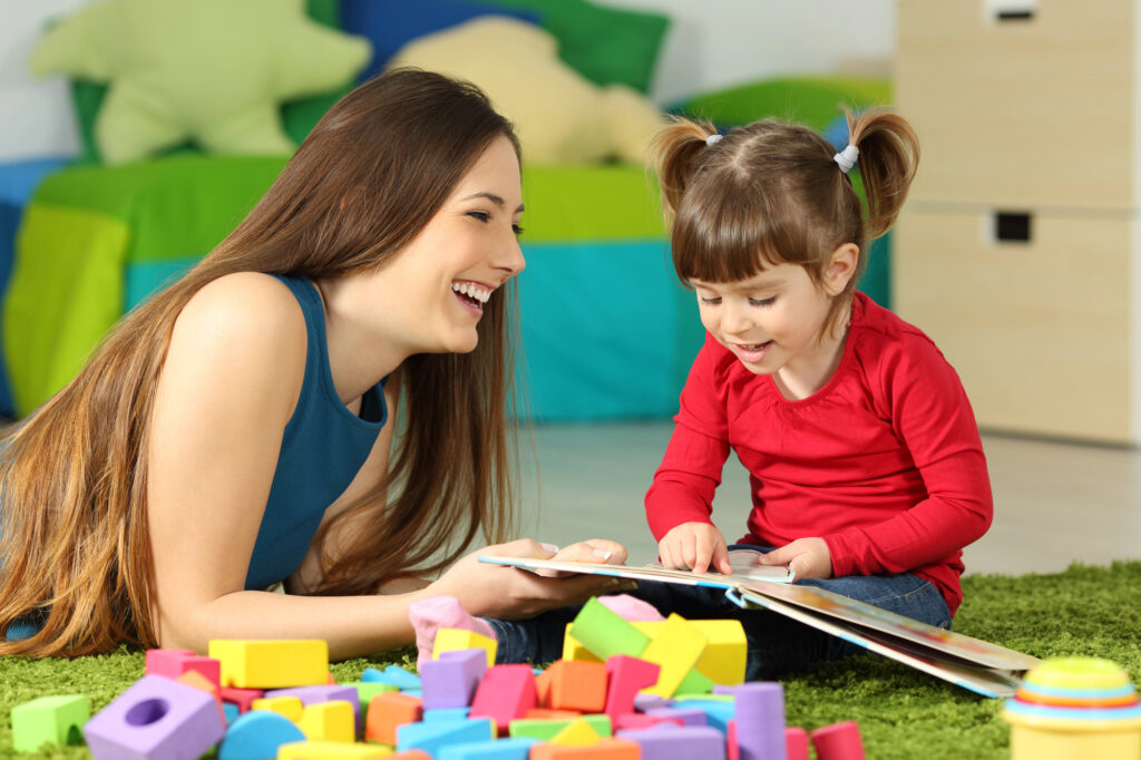 enfant avec nounou qui regarde un livre